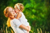 Happy family on summer. little girl child baby daughter hugging and kissing mother